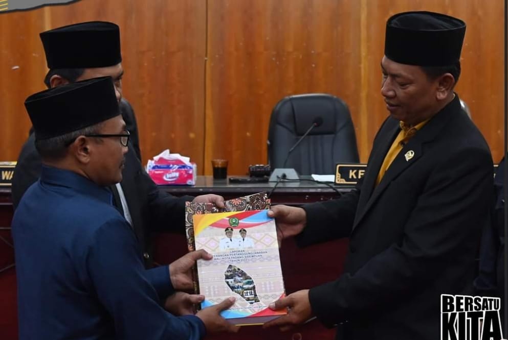 Ketua DPRD Padangsidempuan, Siwan Siswanto,SH.MM saat memberikan Draf LKPJ kepada salah seorang anggota Badan Anggaran DPRD Padangsidempuan, Erfi J Samudera Dalimunthe SH untuk di bahas pada rapat rapat Pansus. ( Photo: Adnan )